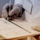 doctor's hands with pen and clipboard writing on a paper form